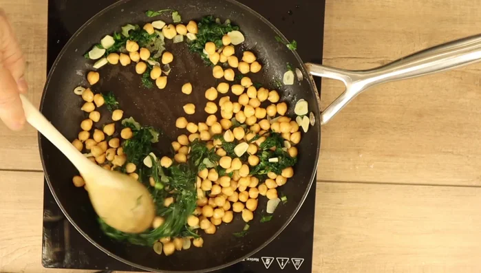Incorporate chickpeas and seasonings: Add the rinsed and drained chickpeas. Season with black pepper. Mix well and cook until heated through.
