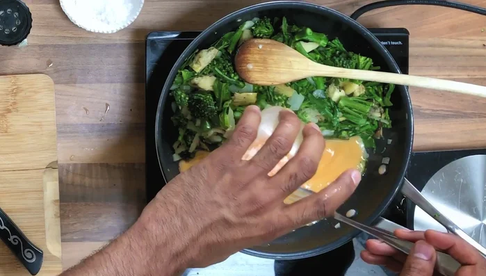 Whisk the eggs and pour them into the well. Continuously whisk to prevent sticking and ensure even cooking.