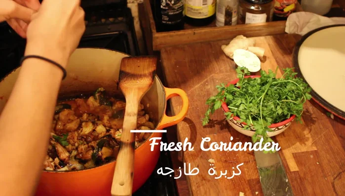 Add water, tomato paste, fresh coriander, and a vegetable stock cube. Mix well.