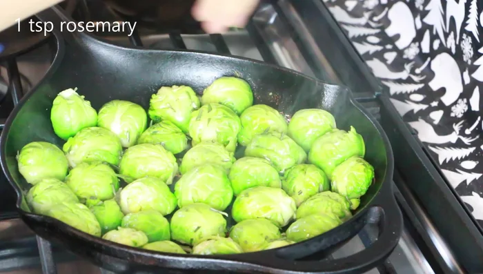 Flip the Brussels sprouts and cook for a few more seconds. Add fresh rosemary.