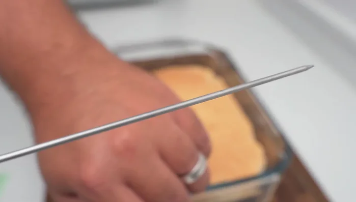 Poke holes in the cooled cake and soak with milk, heavy cream, and sugar mixture for at least 2 hours.