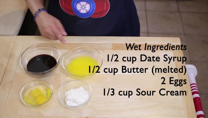 Combine wet ingredients: 1/2 cup date syrup, 1/2 cup melted butter, 2 eggs, and 1/3 cup sour cream.