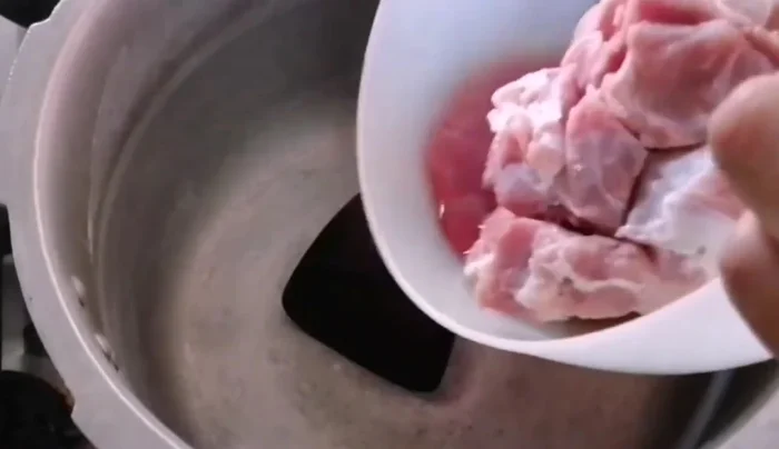 Add mutton and onions to the pressure cooker.