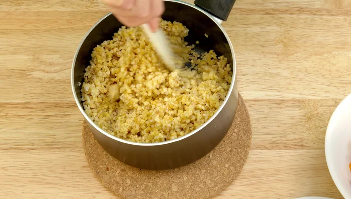 Once cooked, fluff the bulgur with a fork and add it to a large serving bowl. Add the drained and rinsed beans, spring onions, and tomatoes; toss gently.