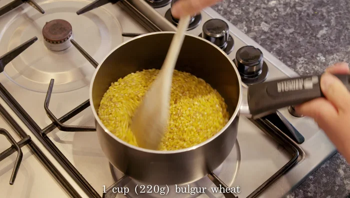 Add the bulgur, stir well to coat in oil, and fry over high heat, stirring constantly, for about one minute.
