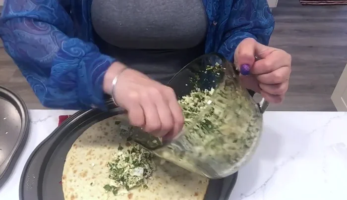 For the first pizza, spread the cheese mixture generously over the crust, leaving the edges empty.