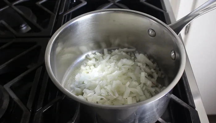 Melt butter in a saucepan over medium-high heat. Add diced onion, a large pinch of salt, and tomato paste. Cook for 5-7 minutes until onions soften and tomato paste caramelizes.