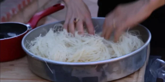 Assemble the Kanafa: Place a spoonful of the nut mixture in the center of a phyllo sheet. Gently wrap and shape into a small package.