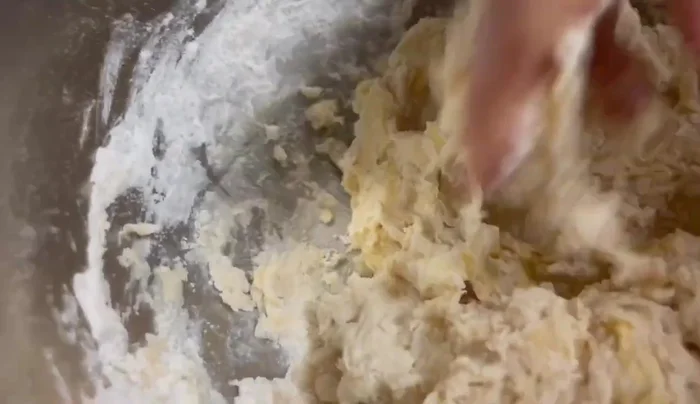 Mix by hand, gradually adding water until the dough is smooth but not kneaded; it should be sticky.