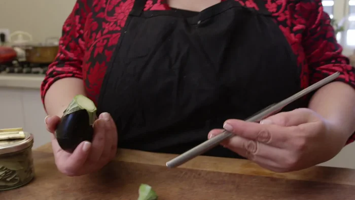 Remove the upper part of the baby eggplants and mark a circle to expose the inside. Scoop out the seeds and inside of the eggplants, being careful to leave the bottom intact.
