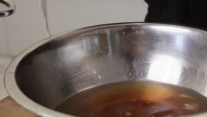 In a pot, combine the sumac water (strained), dried rose petals, additional pepper paste, cumin, chili paste, black pepper, salt, and enough water to reach halfway up the eggplants.