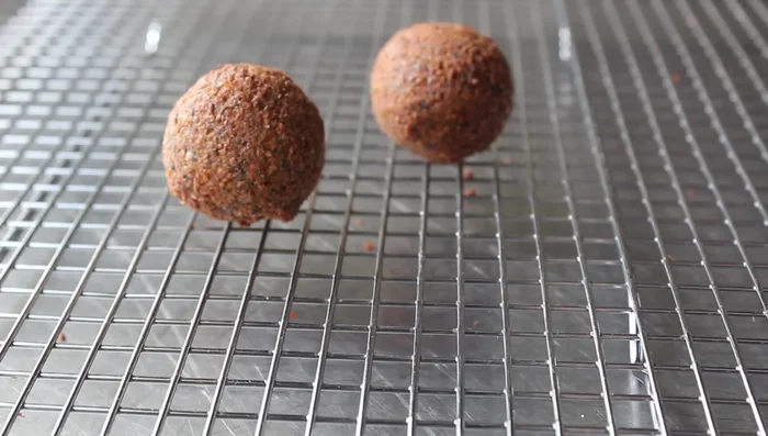 Transfer the cooked falafel to a rack to cool slightly.