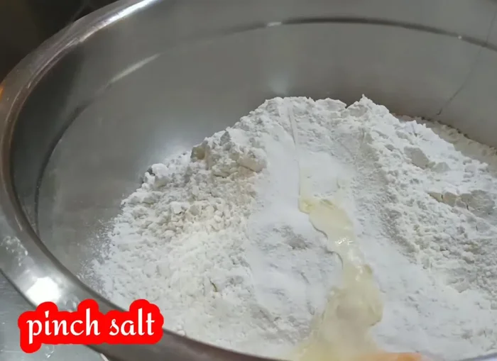 Add one egg, jethmal piece, 1 teaspoon of sugar, 1 tablespoon of milk powder, baking powder, 1 tablespoon of dry yeast, kalyan powder, saffron, saffron colour, and 1 tablespoon of yogurt.