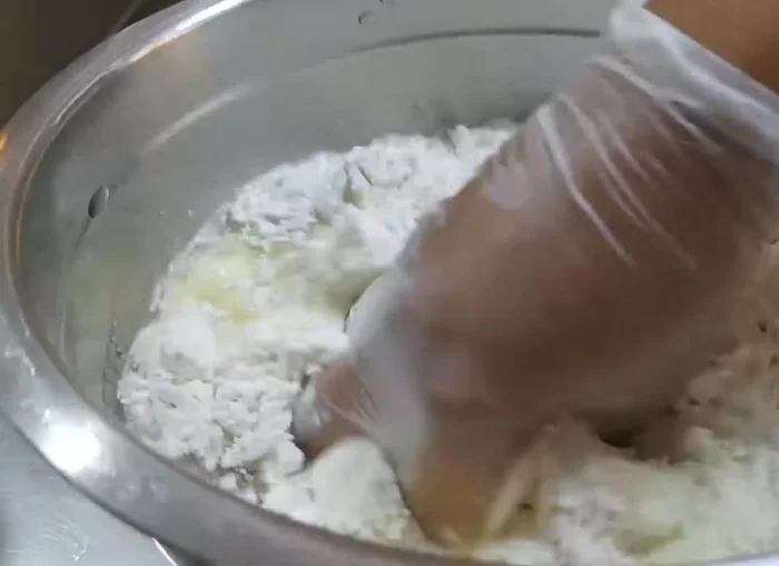 Gradually add water and mix well until a soft dough forms.