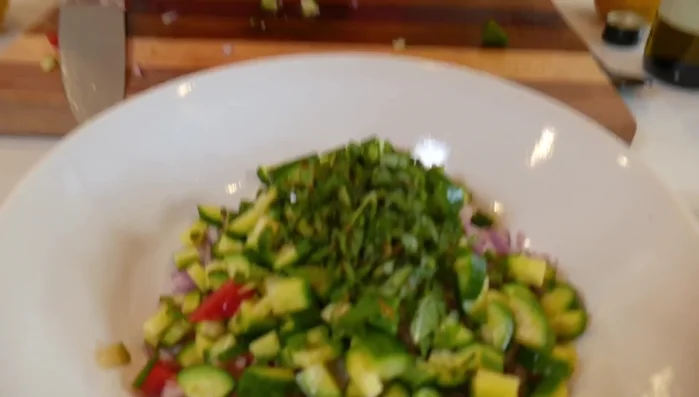 Add the chopped fresh mint and parsley to the bowl.