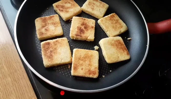 Cook the mbesses in a pan over medium-high heat, flipping to ensure even cooking. The mbesses are ready when they turn golden brown.