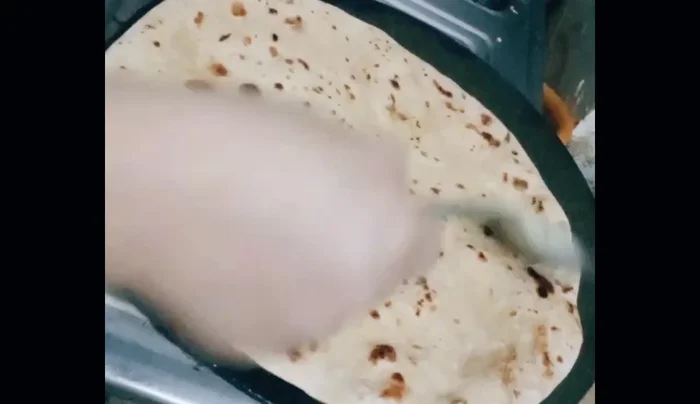 Apply ghee to both sides of the cooked roti to make it crispy.