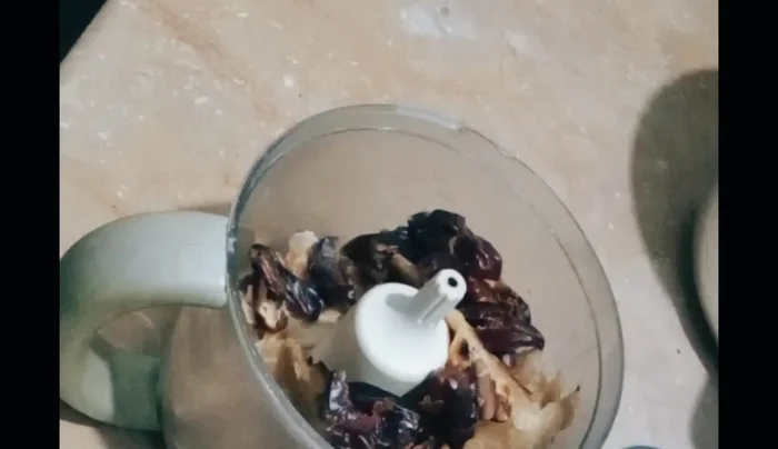 Break the roti into pieces and add it to the chopper along with the chopped dates. Chop well.