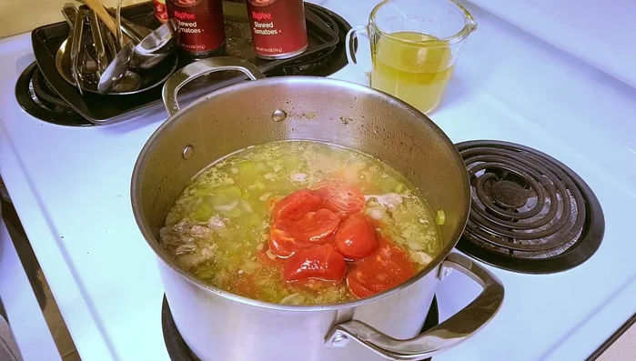 Add canned stew tomatoes and tomato puree.
