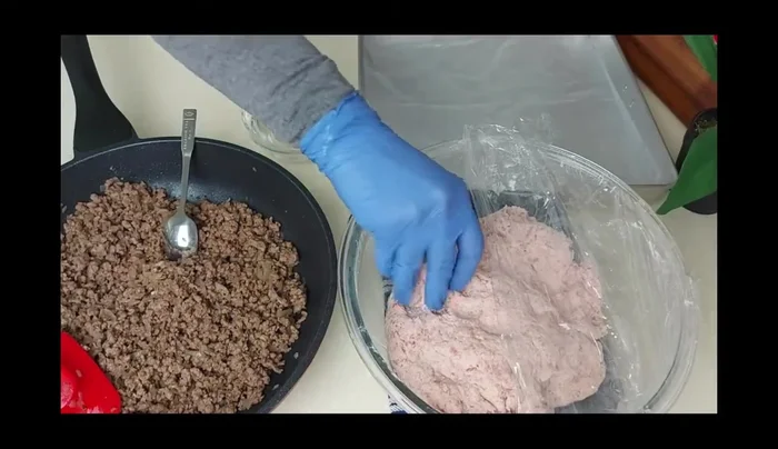 Shape the kubba: Take a small amount of dough, roll into a ball, and flatten it. Use your thumb to create a small cup, then fill with the meat mixture and seal.