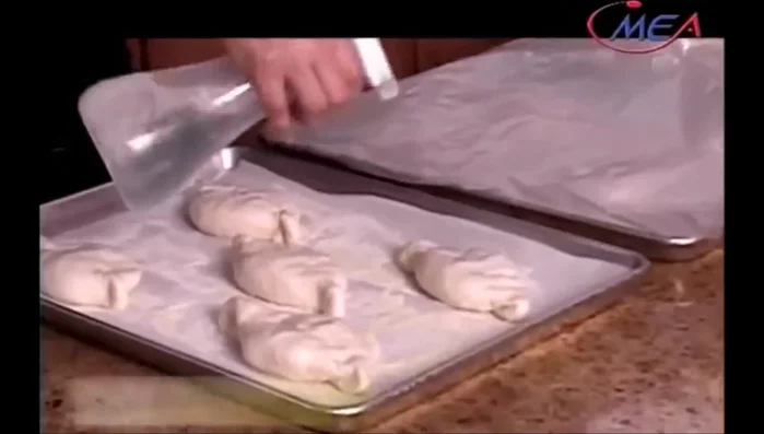 Prepare for baking: Spray the buns with water, sprinkle with sesame seeds, and flatten them slightly. Let rest for another 10 minutes. (Start: 390.639)