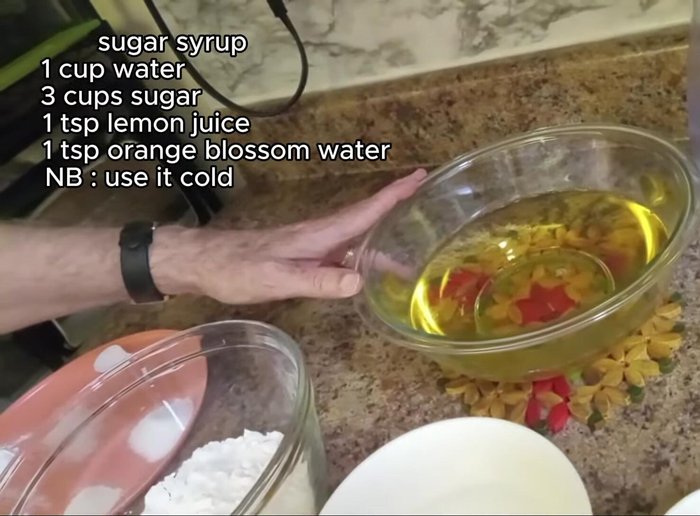 Prepare the syrup: Boil 3 cups of sugar and 1 cup of water until thickened. Add orange blossom water, lemon juice, and simmer until slightly thickened. Let it cool completely.