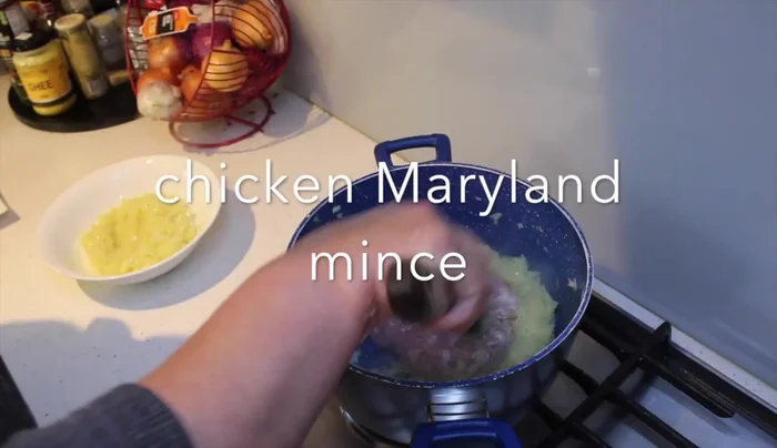 Add minced chicken to the remaining onion in the pot and cook until white.