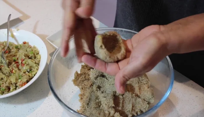 Roll the mixture into balls, create an opening with your thumb, and fill with the chicken filling. Seal the kibbeh tightly.