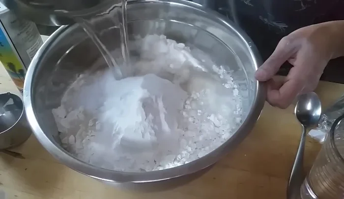 Gradually add water, mixing until a dough forms. The texture should be slightly sticky.