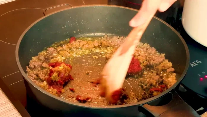 Add saffron, turmeric, pepper, and tomato paste to the meat; keep frying.