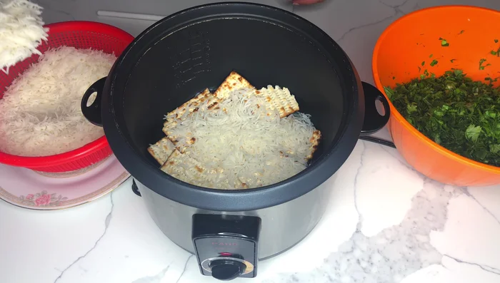 Layer the cooked rice and chopped herbs in the pot, over the ‘tadig’.