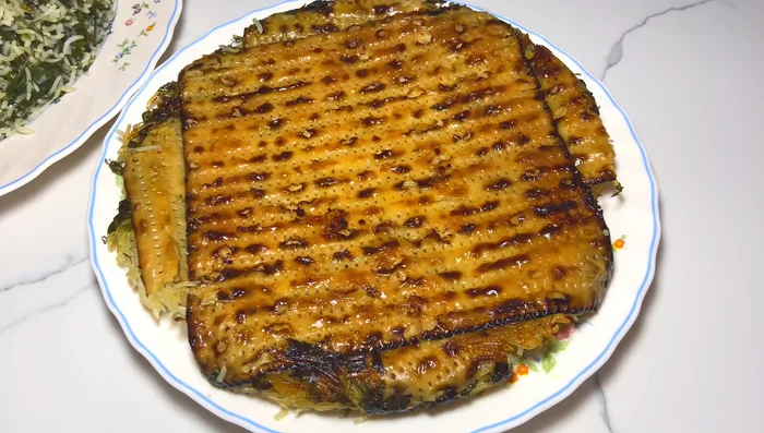 Serve the rice with the fried fish, optionally with pickled garlic and bitter orange or a squeeze of lemon.
