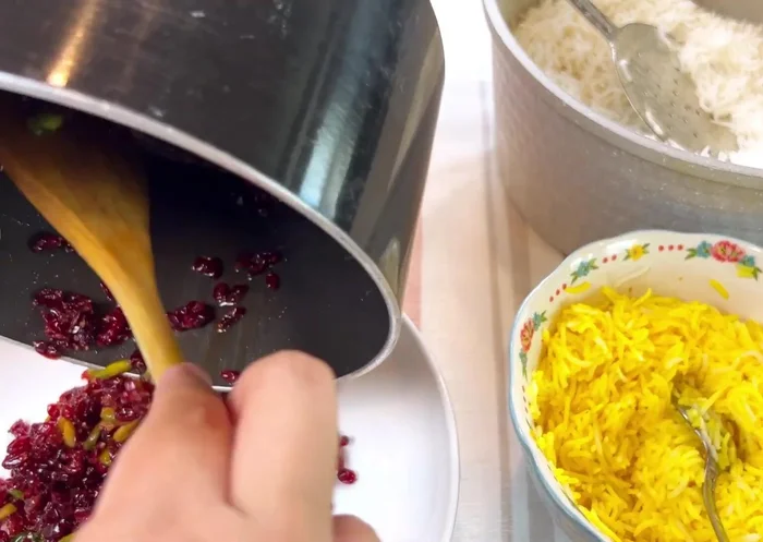 Add some of the saffron rice to your barberry mixture. Mix it together.