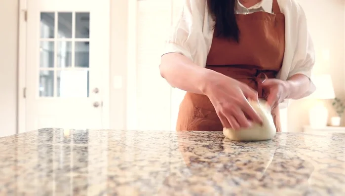 Shape and bake: Shape the dough into a ball, make a cut with a knife. Put the dough in a preheated iron pan, cover and bake at 450°F (232°C) for 20 minutes.