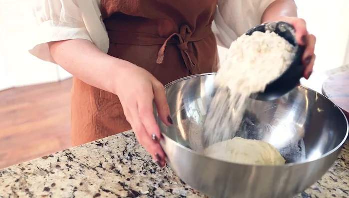 Add remaining ingredients: Add bread flour and remaining water, squeezing the dough until all flour is incorporated. Knead in the salt.