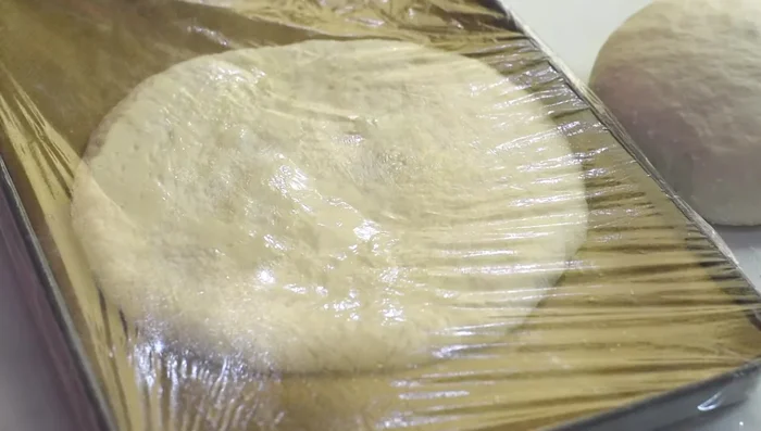 Cover with greased plastic film and let the dough puff up for 25 minutes.