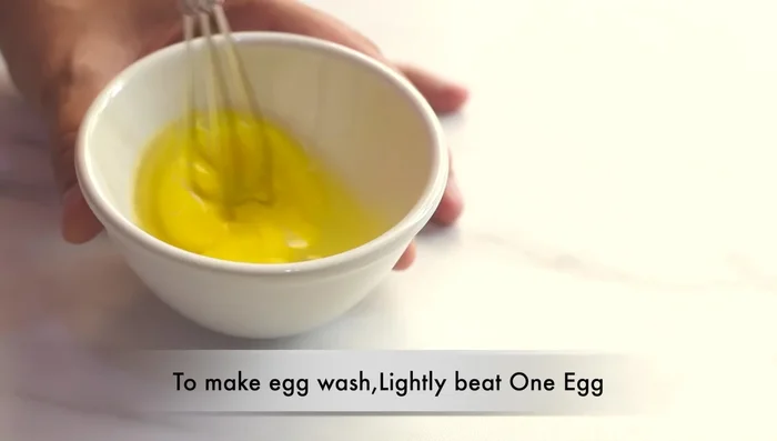 Brush the tops with egg wash, create patterns with your fingers, and sprinkle with sesame and nigella seeds.