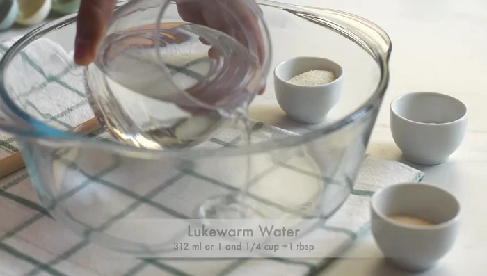 Prepare the bread dough: In a bowl, add lukewarm water, salt, sugar, and yeast. Stir until combined.
