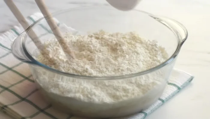 Add flour gradually, mixing until a well-hydrated dough forms. No dry patches should remain.