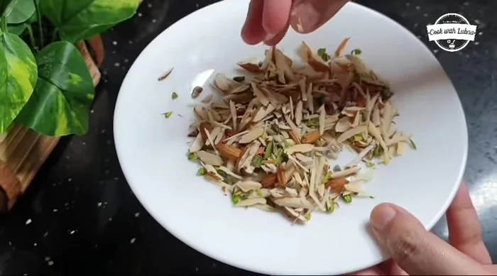Add dry fruits and ghee: Brush each rolled-out piece with water and ghee. Sprinkle with dry fruits. Roll it slightly.