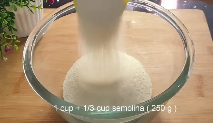 In a mixing bowl, combine semolina, sugar, and oil (or butter). Mix until it resembles breadcrumbs.
