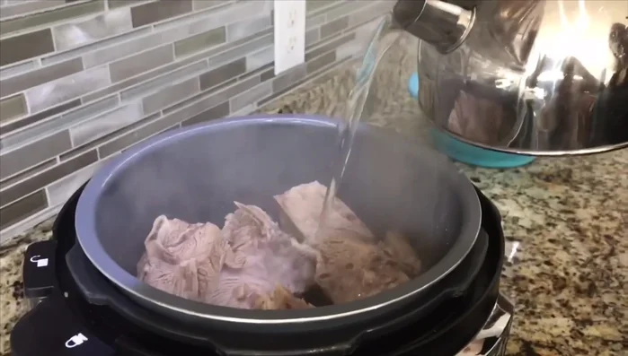 Place the rinsed lamb meat into a pressure cooker (or stovetop pot). Pour boiling water over the meat until completely covered.