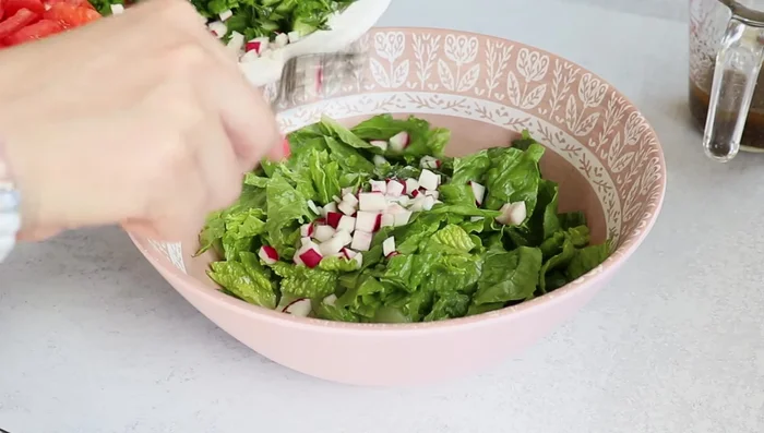 Add most of the chopped vegetables and herbs to a bowl.
