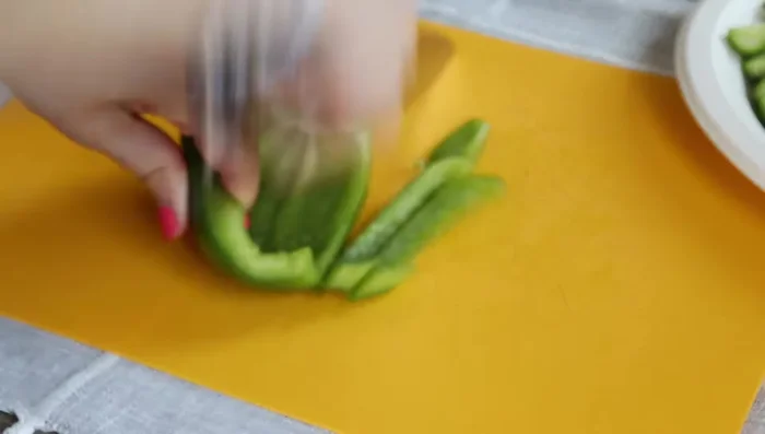 Chop cucumbers, green bell peppers, radishes, tomatoes, and parsley.
