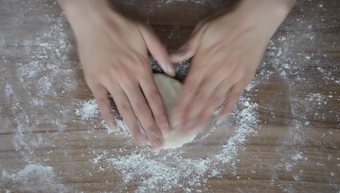 Flatten each dough ball with your palm, then use a rolling pin to roll it out to about 8 inches wide. (take one doble uh flatten it with your palm and then use a rolling pin to flatten that out to about 8 in)