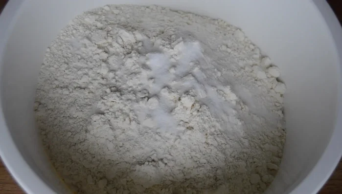 Combine flour, salt, oil, and yeast mixture in a large bowl. Gradually add water, mixing until a dough forms. (Add all the ingredients onto the flour)