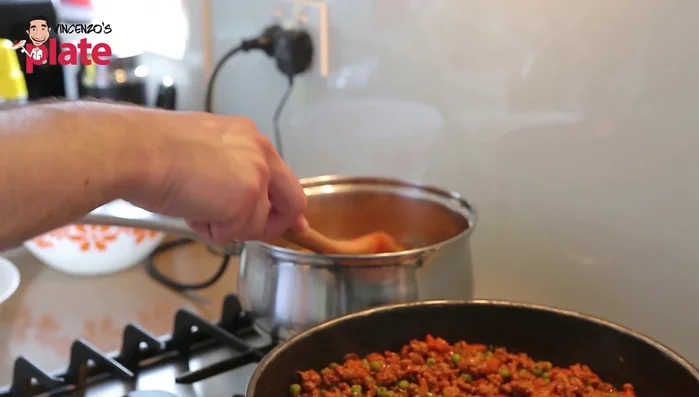 Add 1 liter of water (for 500g rice), bring to a boil. Add a spoonful of tomato sauce, peas, and vegetable stock cube (167.08).