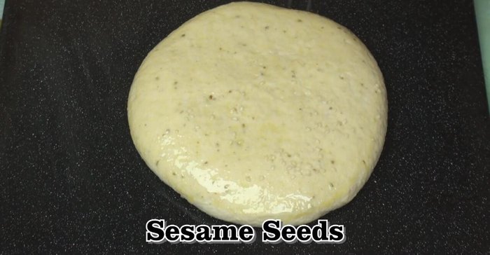 Brush the tops with olive oil and sprinkle with sesame seeds. Jab a few times with a fork.
