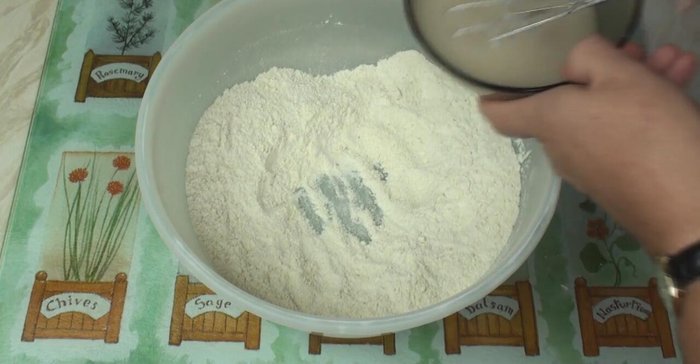 Make a well in the flour mixture and add the yeast water. Mix until a smooth dough forms.