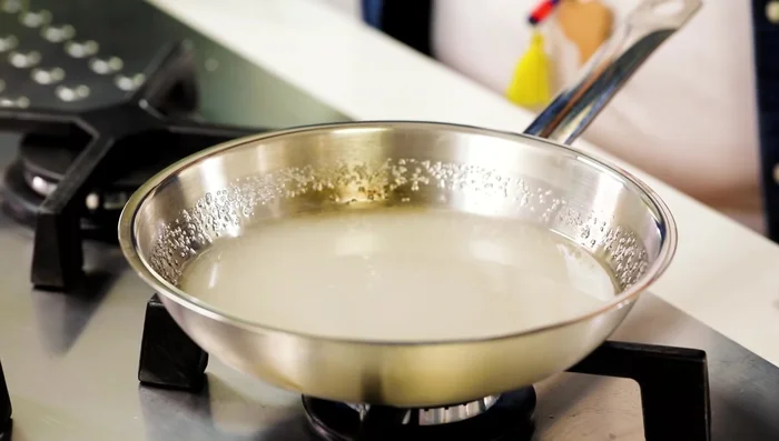 Melt sugar and water in a pan over medium-low heat, stirring to prevent crystallization.